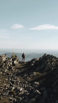 Mountaineer standing on ridge of Puebla de la Sierra Mountains, Spain