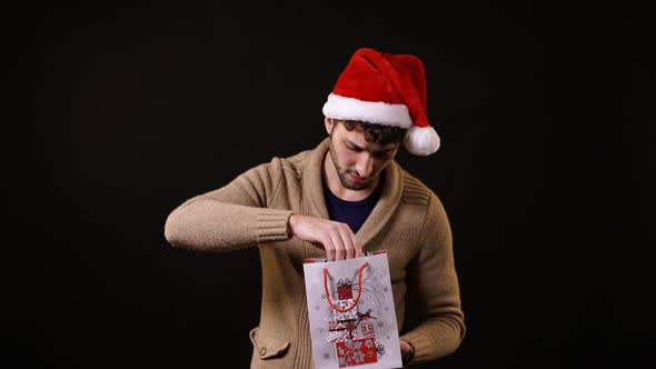 A man taking a present out of a paper bag