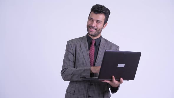 Happy Bearded Persian Businessman Thinking While Using Laptop