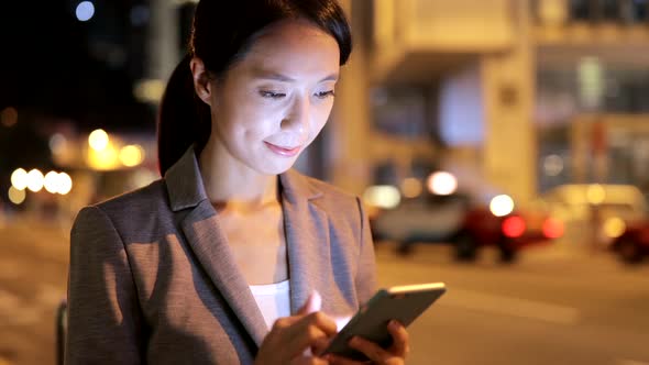 Woman looking at mobile phone at night 