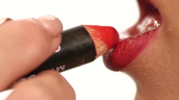 Makeup Artist Tracing Red Contour on the Lips of a Girl. Slow Motion