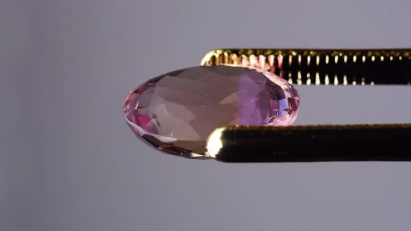 Natural Ametrine in the Tweezers on the Background