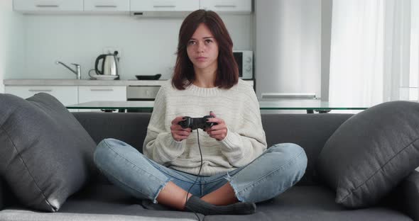 Funny Attractive Girl with Long Hair Playing Video Games with Joystick