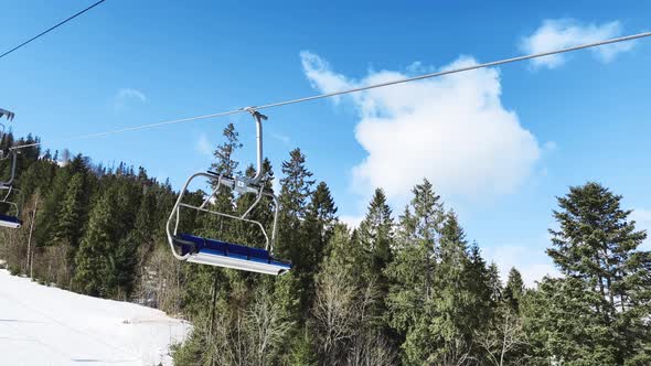 POV Empty Ski Lift Snowy Mountain Winter Forest with Chair Lift At The Ski Resort in Winter