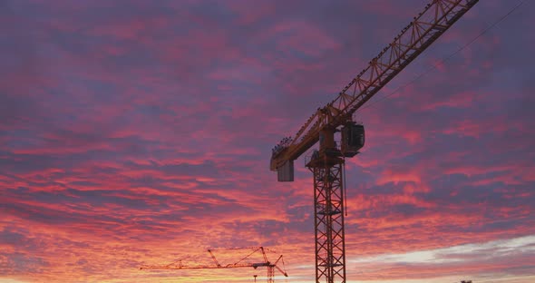 Golden bluish clouds over construction site glow in the light of a sunset