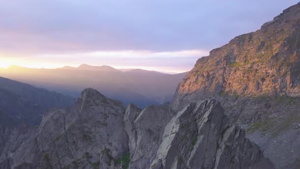 Rugged mountain peaks and narrow sharp ridge high in mountains of Romania with stunning sunset sky f