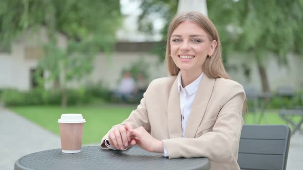 Young Businesswoman Smiling Towards Camera in Outdoor Cafe