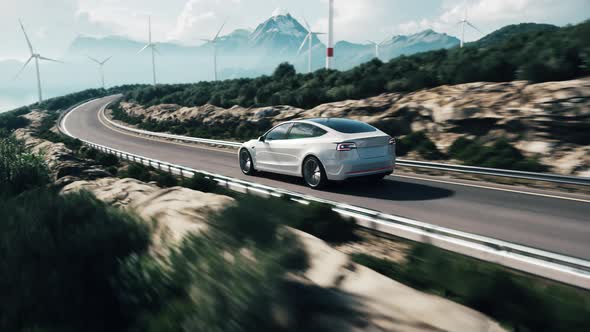 Electric Car Driving Along Windmills Farm. Alternative Energy For Cars alt