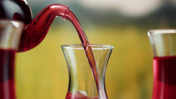 Pouring Red Fruit Tea Into Armudu Glass Cup Closeup