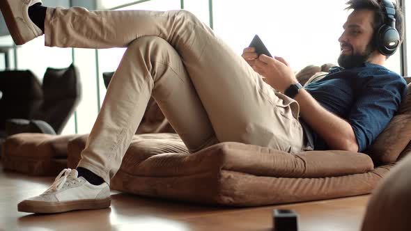 Healthy Stress Free Man Relaxing In Office And Listening To Music. Employee Taking Break On Work.