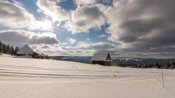 Snow covered house in the mountains in a cloudy winter day