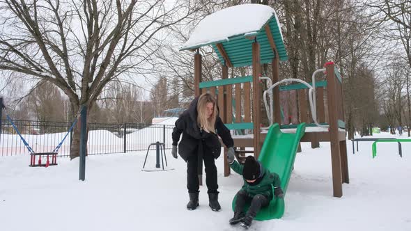 Little Boy Slides Down the Children's Slide