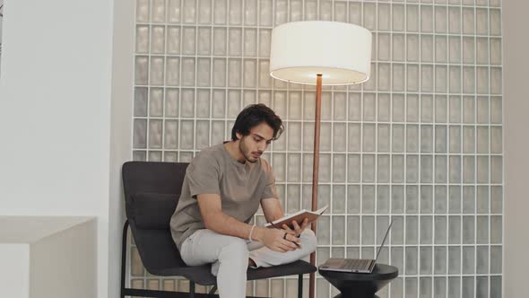 Young Man Keeping Journal in Room