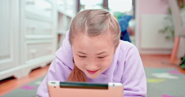 Teen Girl is Smiling When Touches the Tablet alt