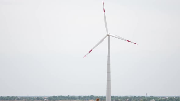 Camera Pulls Back to Show an Aerial View of a Long Row of Offshore Wind Turbines in the Sea Against