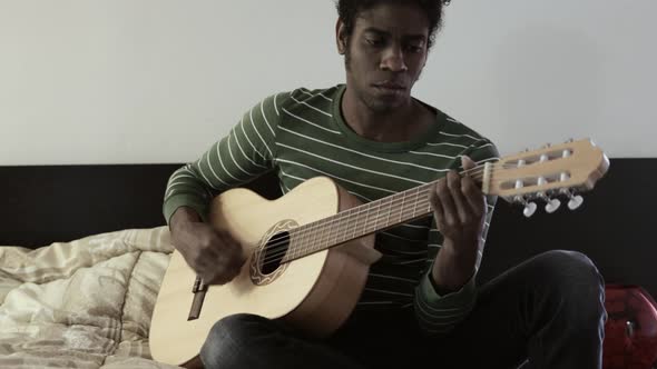 Man playing guitar at home