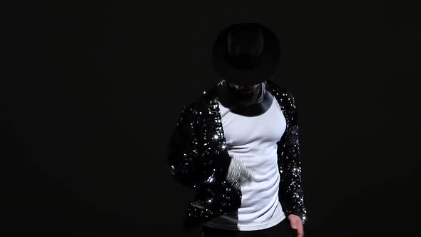 Young Stylish Man Dancing in Style Michael Jackson, Spotlight on a Black Background. Close Up
