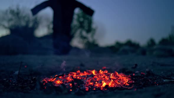 Halloween witch by the fire. Death in the dark misty forest with fire