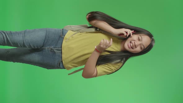 Asian Girl Student Talking On Mobile Phone And Running To School On Green Screen Chroma Key