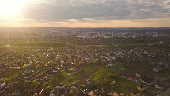 Aerial view of rural area in town with residential houses at sunset summer evening