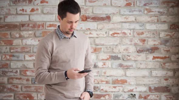 Man Browsing Web on Cellphone Indoor