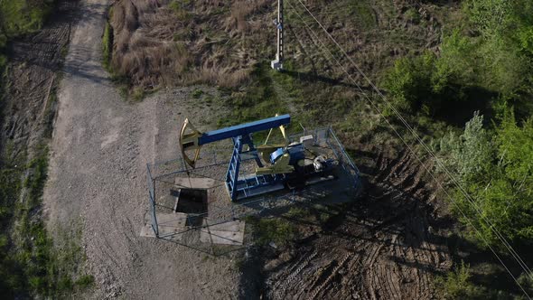 Aerial View Of Oil Pump Equipment Beside The Highway Near Campina, Romania. aerial, orbit