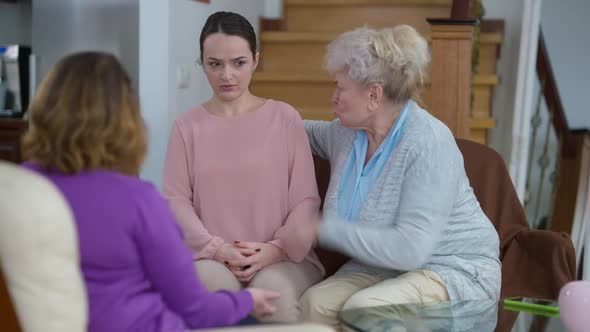 Angry Dissatisfied Furious Grandmother and Mother Yelling at Sad Stressed Young Woman and Depressed
