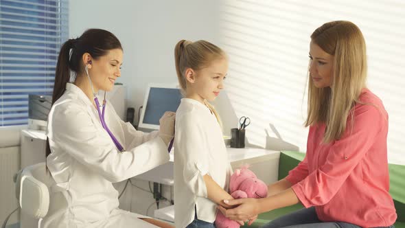 Female Pediatrician Practitioner Checking Little Patient's Lungs Listening To Breath Through