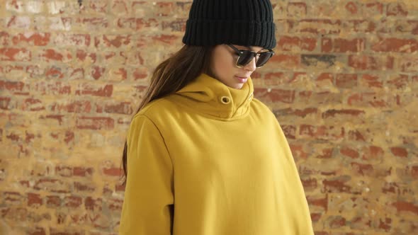 Caucasian woman showing her outfit on a brick wall