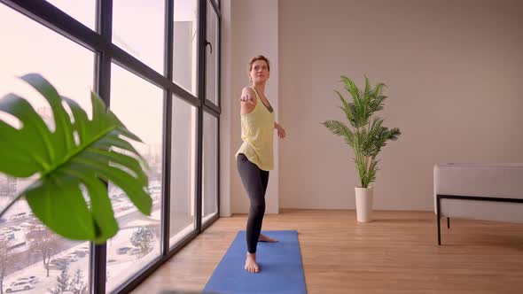 Female in Sportswear Stretching in Flat