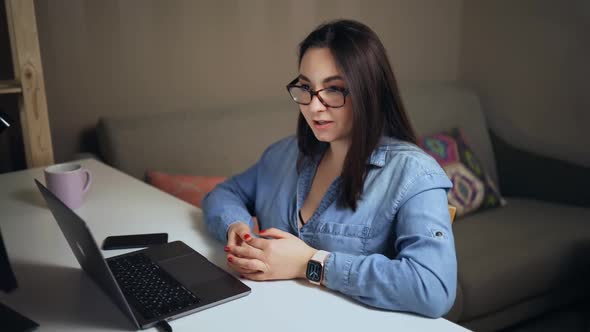 Young Woman During Online Conference Talking to Colleagues Using Streaming App on Laptop