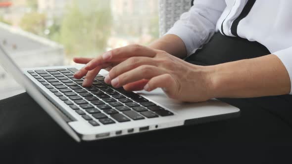 Woman's fingers typing on laptop keyboard. Human hands on keyboard. Business concept