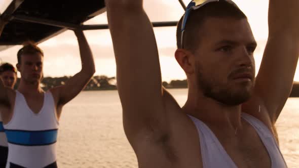 Male rower team carrying the boat above their heads