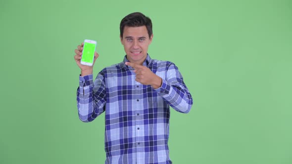 Happy Young Handsome Hipster Man Showing Phone and Giving Thumbs Up