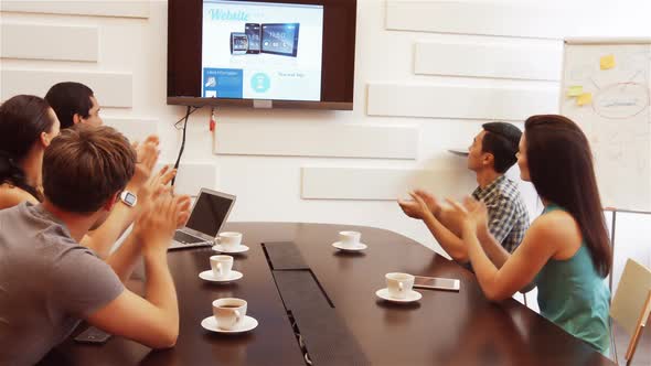 Business executive applauding during a video conference