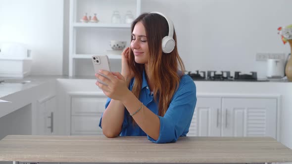 Teenage Girl Listening to Music on Smart Phone at Rustic Kitchen