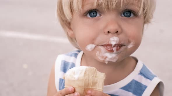 a Small Child Eats White Ice Cream with Great Pleasure