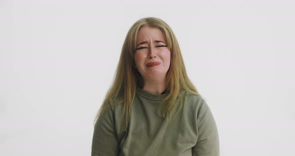 Emotional Woman in Green Sweatshirt Cries Looking in Camera