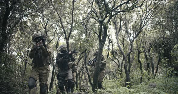Squad of fully armed commando soldiers during combat in a forest scenery alt