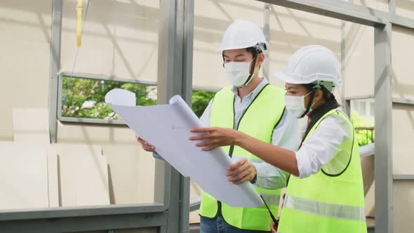 Asian workers people wearing protective face mask onsite of architecture due to COVID pandemic.