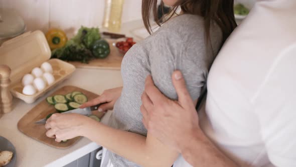 Happy Man Caressing Girlfriend in Kitchen in Morning