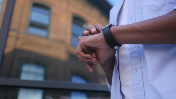 Browsing Online on Smartwatch, Standing Young Black Male Designer