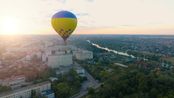 Several Hot Air Balloons Floating Over City Toward Rising Sun Over Horizon, Hope