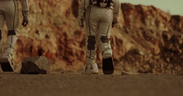 Unrecognizable Astronauts Walking on Arid Ground of Mars