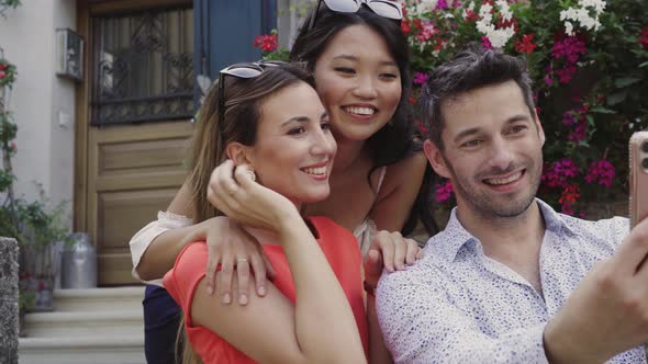 Three friends taking a selfie with smartphone