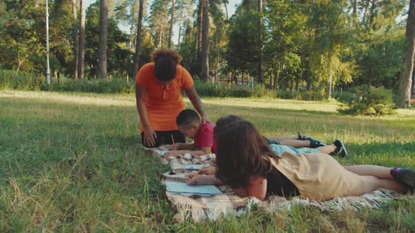 Side View of Multiethnic Diverse Pupils Writing Exam Test Outdoors