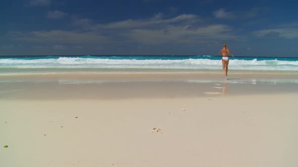 Woman Running in the Ocean From Beach