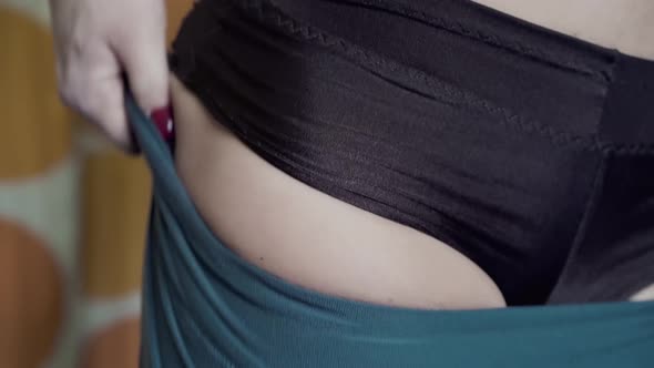 Young Girlathlete in the Locker Room of the Gym Putting on Pants Closeup