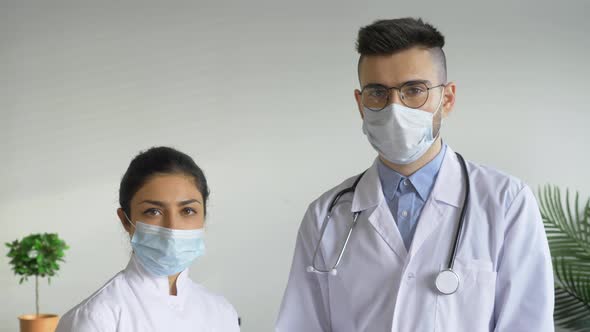 Portrait Two Doctors A Man and a Woman Looking at the Camera Are in a Bright room in the Hospital