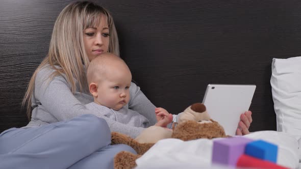 Young Mother with Little Daughter Son Rest with Computer Tablet